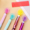 A collection of diamond painting pens in various colors, including pink, mint green, and purple, laid out on a light backgrou