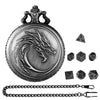 A detailed metal dragon-themed pocket watch dice case with seven small cubic dice and a chain.