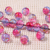 A string of iridescent pink and blue gradient crystal glass beads with a golden crackle finish
