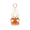A white Miffy plush keychain charm with a gold ring and an orange checkered fabric.