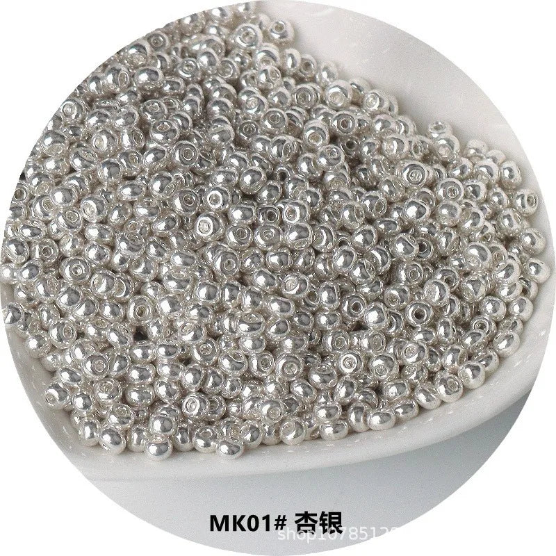 A pile of small, silver-colored electroplated metallic glass beads for jewelry and crafting.