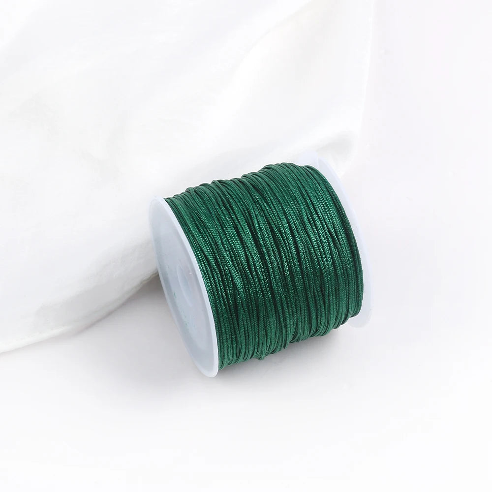 A roll of dark green 0.8mm cotton nylon macrame cord for jewelry making and crafts.