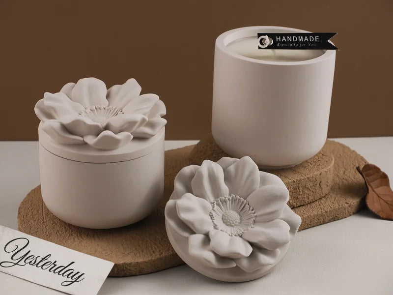 A white floral silicone mold for decorative storage jars and candle cups sits on a cork coaster.