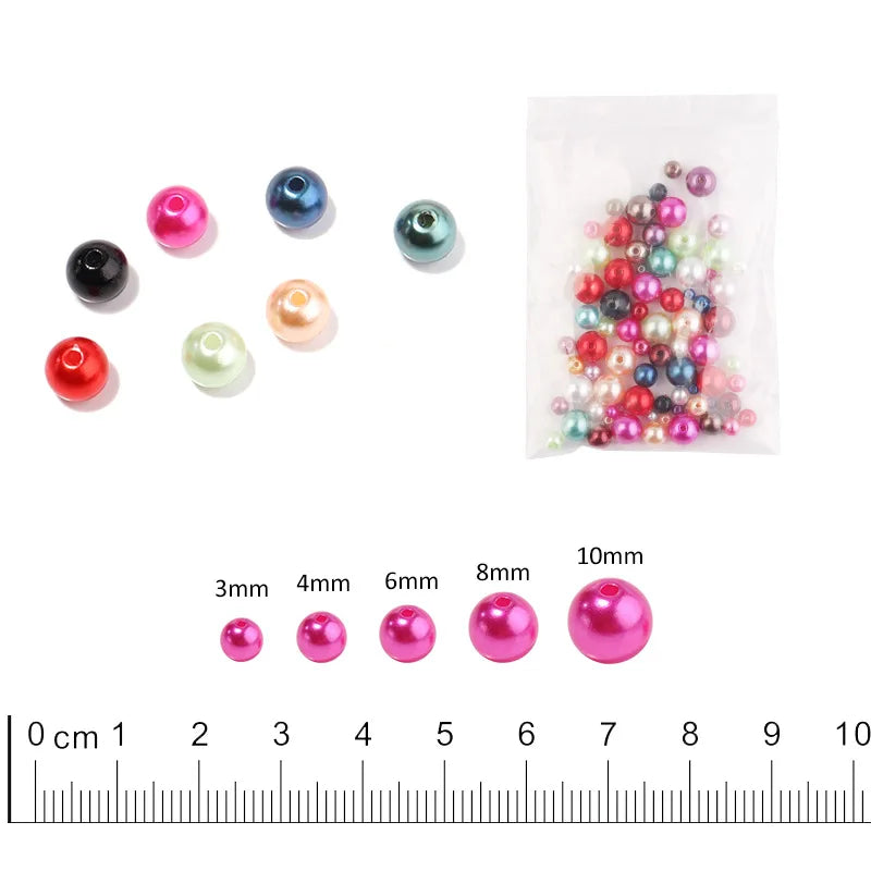 A collection of colorful imitation pearl beads in various sizes and shades, including pink, blue, green, and black.