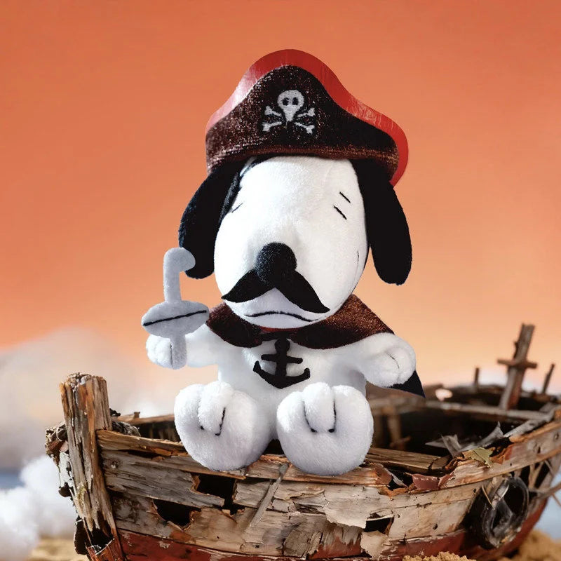 A collectible figure of Snoopy with a black and white face, wearing a red hat and a dark collar, sitting on a wooden crate.
