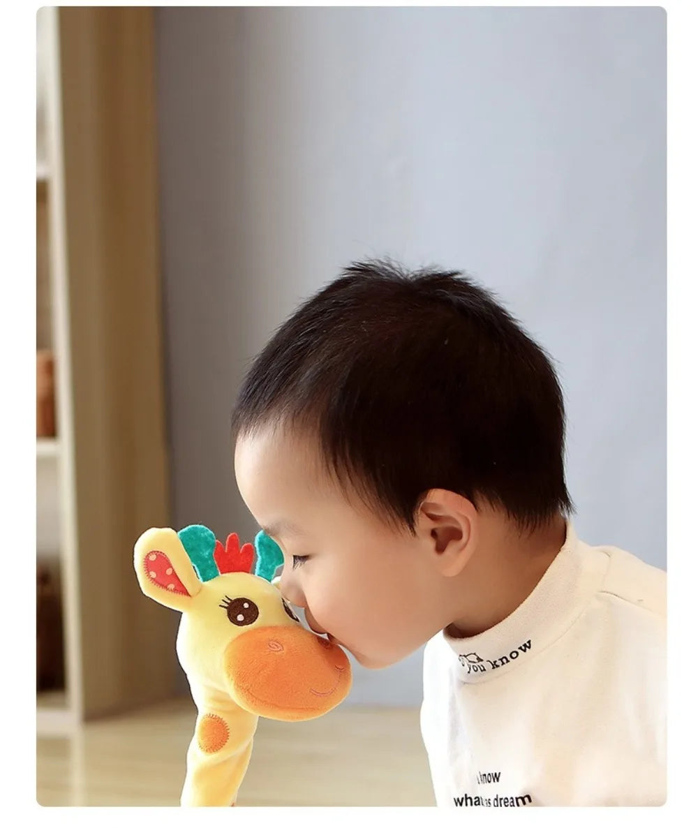 A baby is interacting with a yellow dancing talking giraffe plush toy.