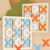 Wooden tic tac toe board game with wooden and wooden cross pieces in orange, blue, and white