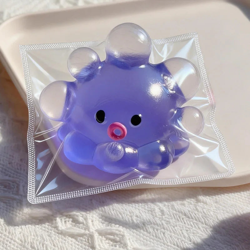 A purple squishy bubble squid stress relief toy packaged in clear plastic on a white surface.