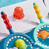 A collection of water bath toys including an orange rubber duck, a yellow squirting toy, and a purple turtle in a blue bath.