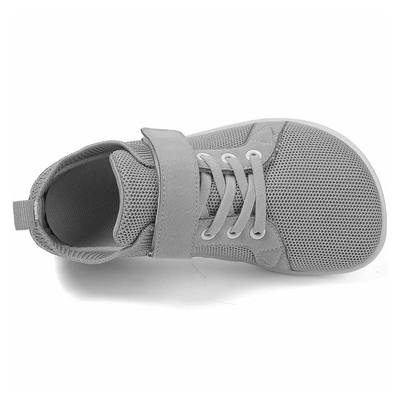 A gray pair of kids barefoot training sneakers with a wide toe box shown from the top view.