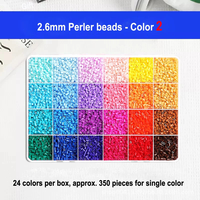 A display of 24 colors of 2.6mm perler beads in a box, showing various shades of blue, pink, yellow, and orange.