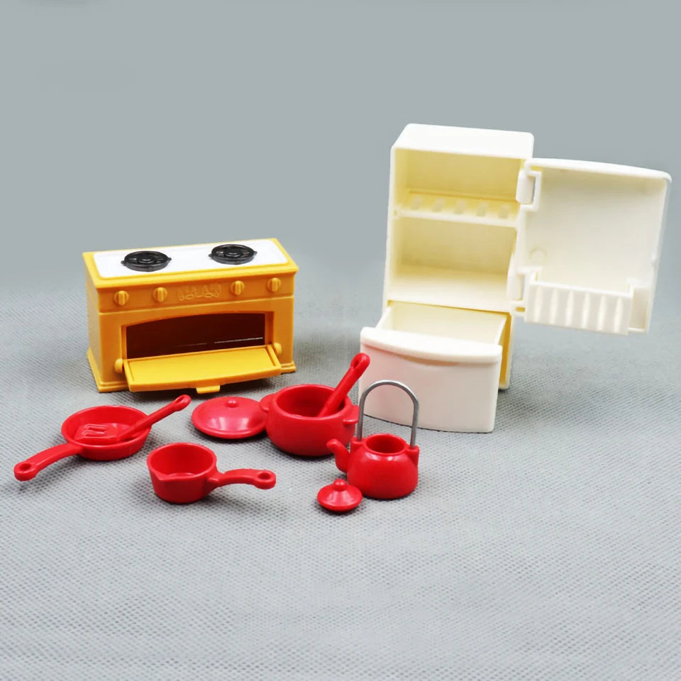 A set of yellow and white dollhouse furniture including a stove, pots, and utensils.