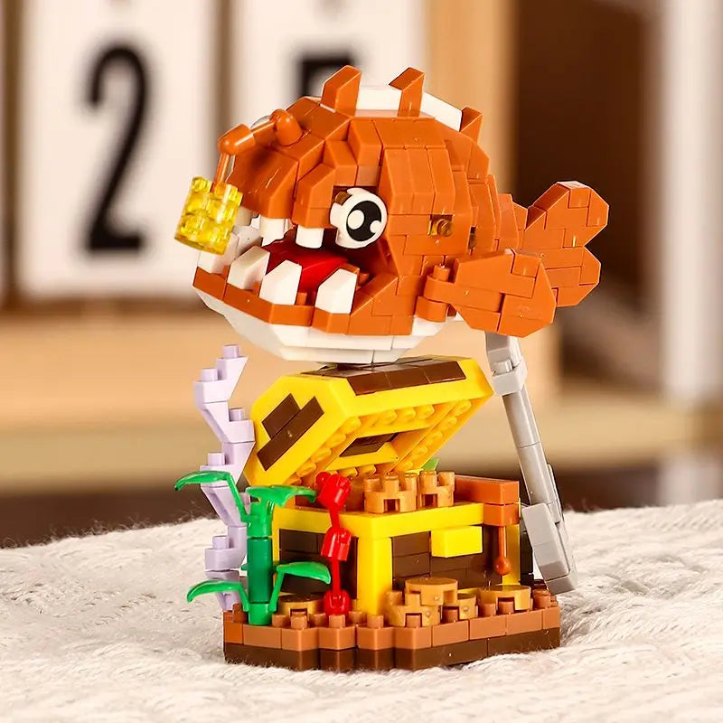 An orange shark building block figure with yellow teeth and a white body stands atop a yellow base.