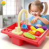 A child is playing with a red plastic kitchen sink toy that features running water and play food.