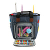 A dark blue canvas tote bag with organizer pockets and a clear interior showing various knitting tools and yarn.