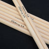 A pair of light wood drumsticks with 'Moboog 5A' markings are shown against a dark background.