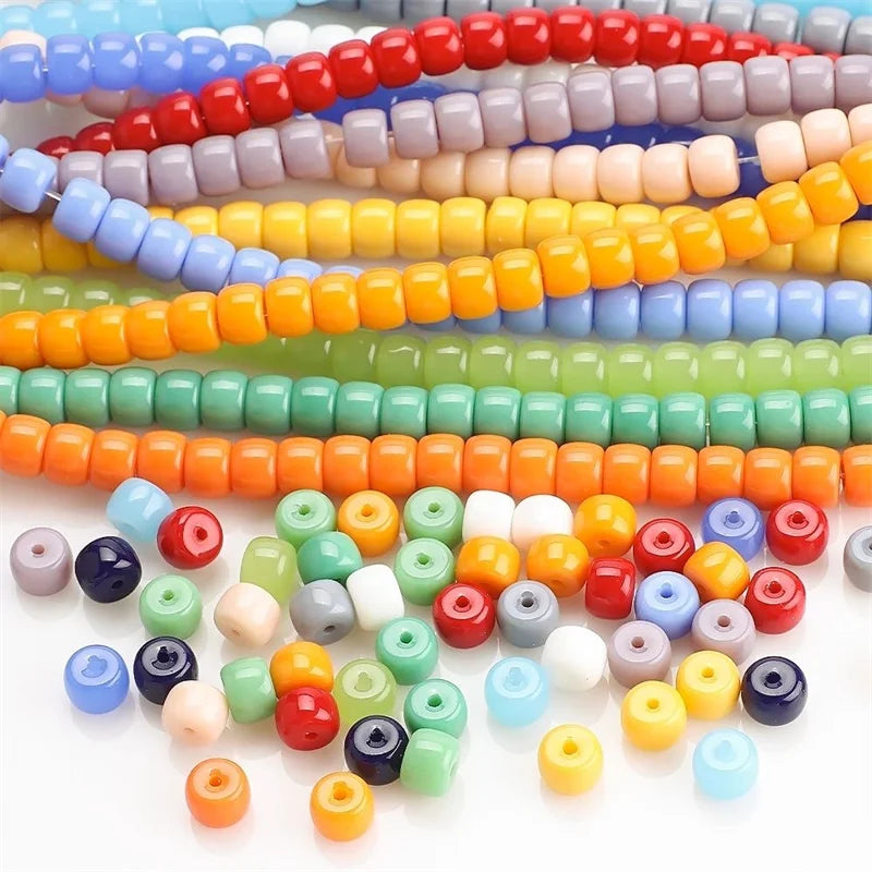 A collection of colorful pony beads in various shades of pink, yellow, green, blue, and orange arranged in rows.