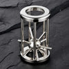 A stainless steel brain teaser puzzle lock set with a circular top and multiple protruding pins.