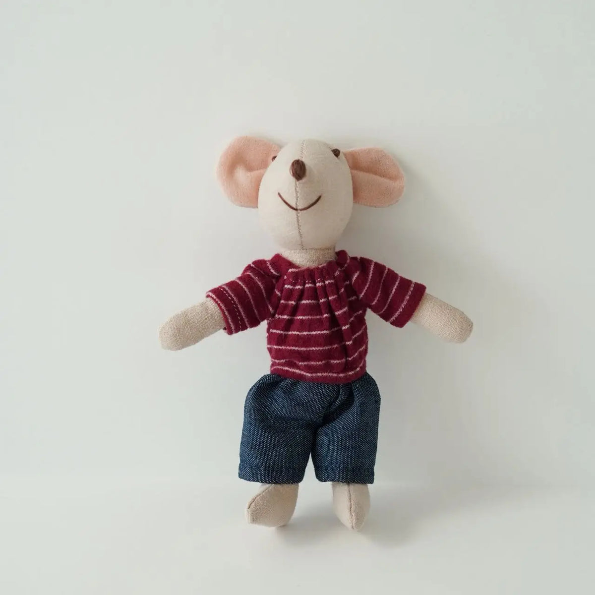 A handmade mouse plush doll with pink ears and a red striped shirt and dark blue shorts.