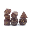 A set of seven mini polyhedral RPG dice in various shades of brown and gold.