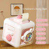 A pink and white children's busy ball cube featuring various sensory elements like a whistle, music, goppers, and a steering 