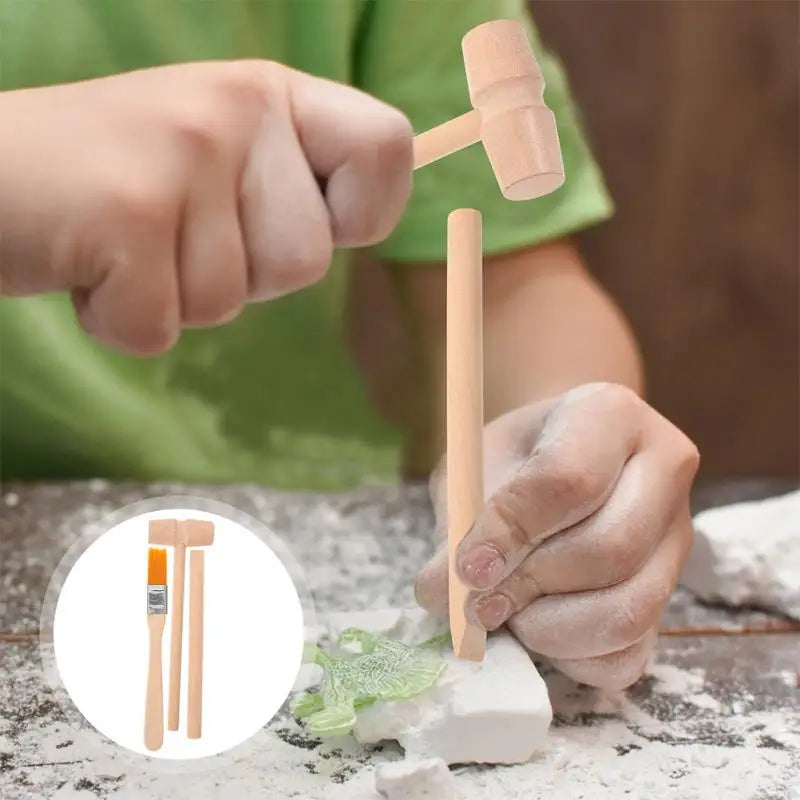 A child uses a hammer, chisel, and brush to excavate fossils from a block of plaster in a dinosaur excavation kit.
