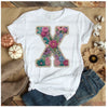White t-shirt featuring a large embroidered floral letter X design on the chest