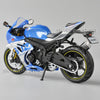 Blue Suzuki GSX-R1000R diecast motorcycle model in a studio setting.