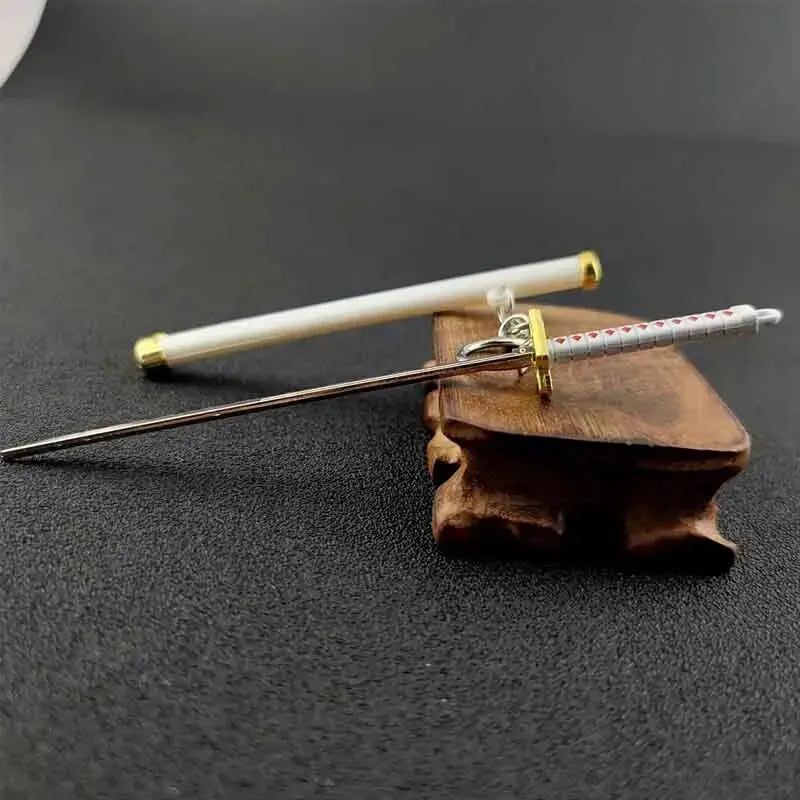 A samurai sword keychain featuring a white blade and hilt resting on a dark surface.