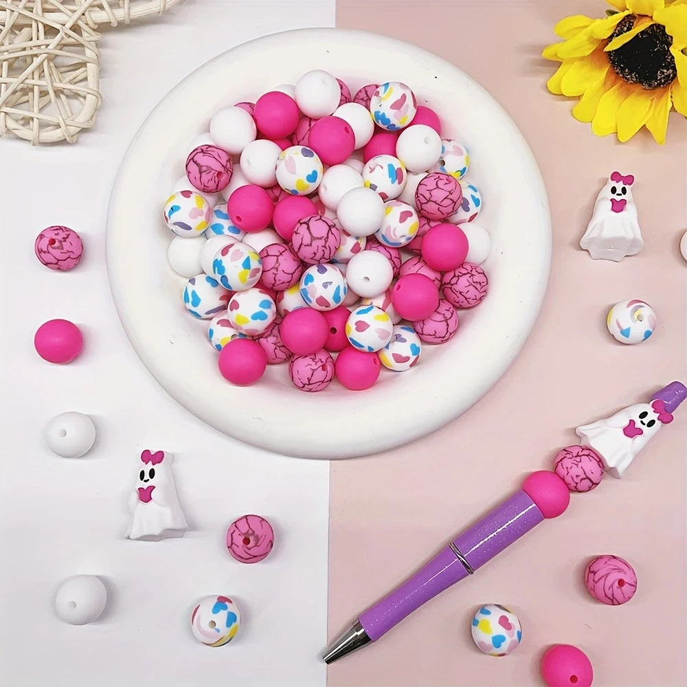 A collection of 25 silicone beads in various pink and white colors are displayed on a white plate and scattered around.