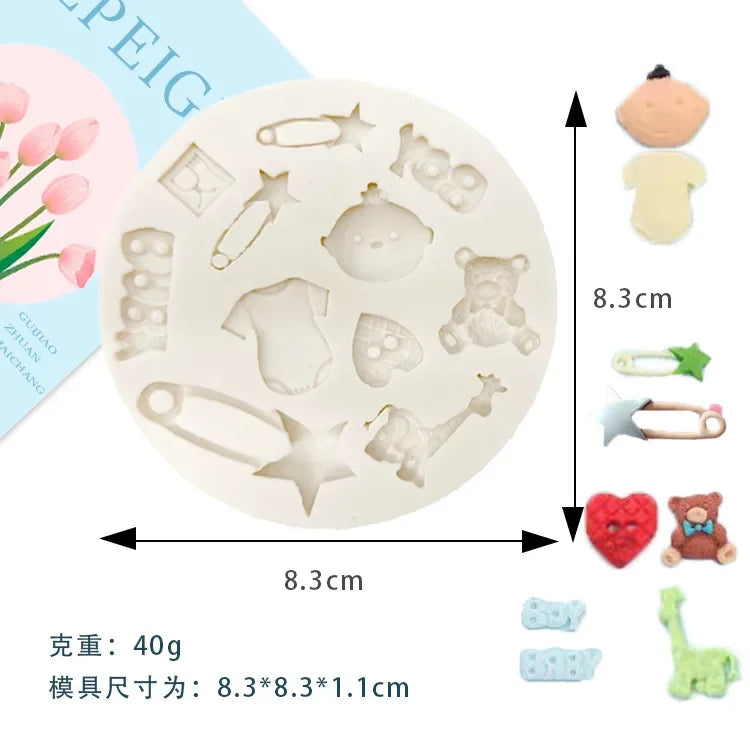A set of silicone baby-themed cake molds including shapes like a pacifier, bottle, and teddy bear, displayed on a white plate