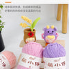 Purple and pink chenille yarn balls with tags displayed on a wooden tray