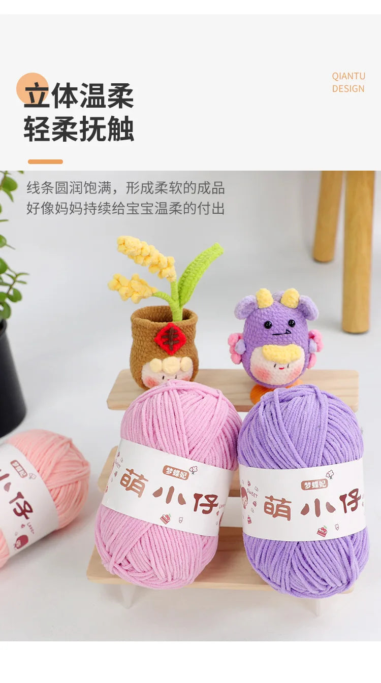 Purple and pink chenille yarn balls with tags displayed on a wooden tray