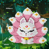 A white and pink nine-tailed fox building block set is displayed in a forest setting surrounded by green foliage.