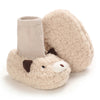 A pair of light beige, fluffy cartoon animal baby booties with a knitted cuff and a soft sole.
