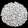 A pile of small white acrylic alphabet letter beads for jewelry making
