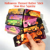 A hand holds a Halloween themed butter stick slow-rise squishy toy in various colors and designs.