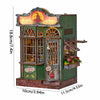 A miniature wooden dollhouse kit featuring a shop facade with large windows and a sign.