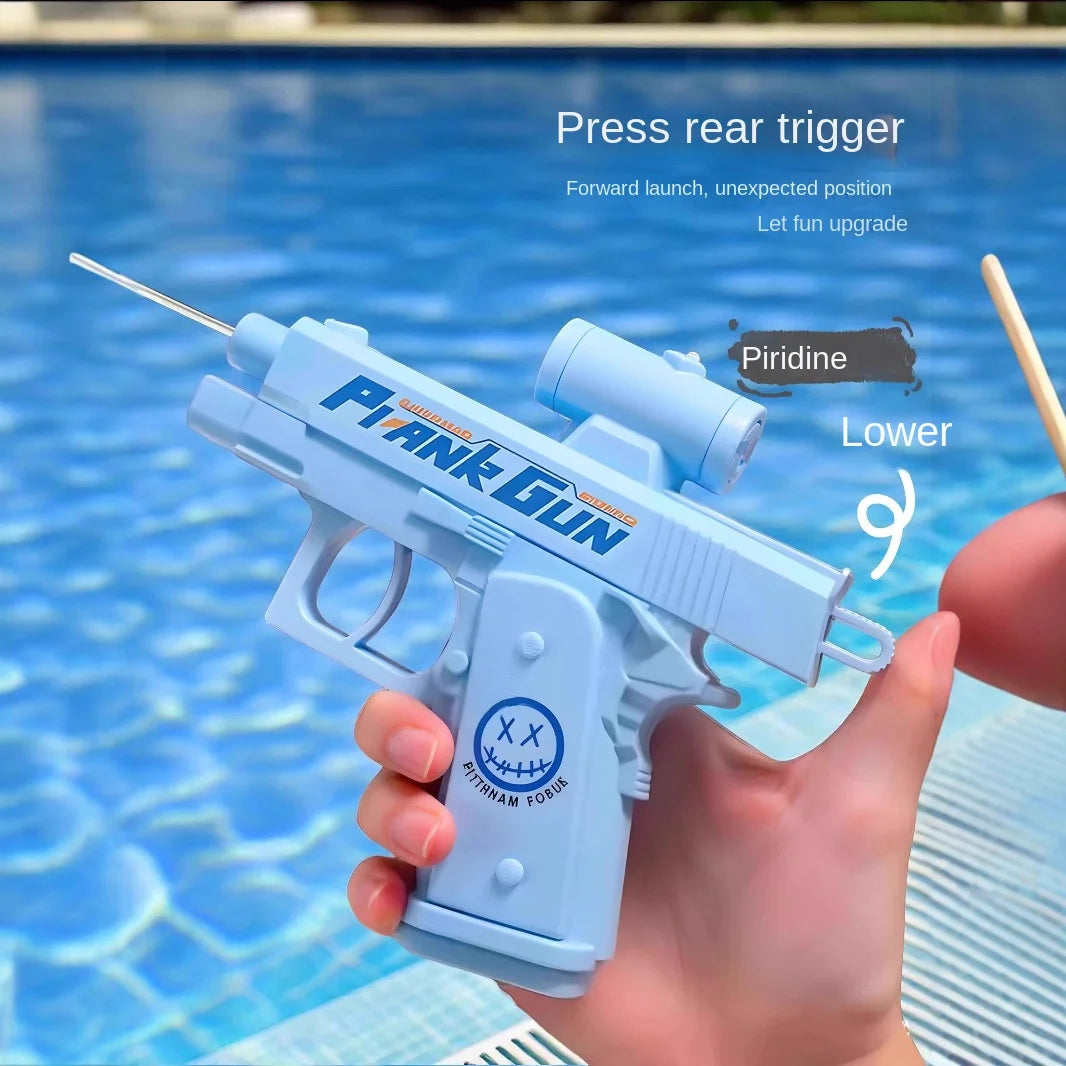 A hand holds a light blue plank gun water gun with a press rear trigger, set against a blue swimming pool background.
