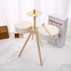 A wooden kids drum set with a light wood stand and two round white drums is displayed on a white surface.