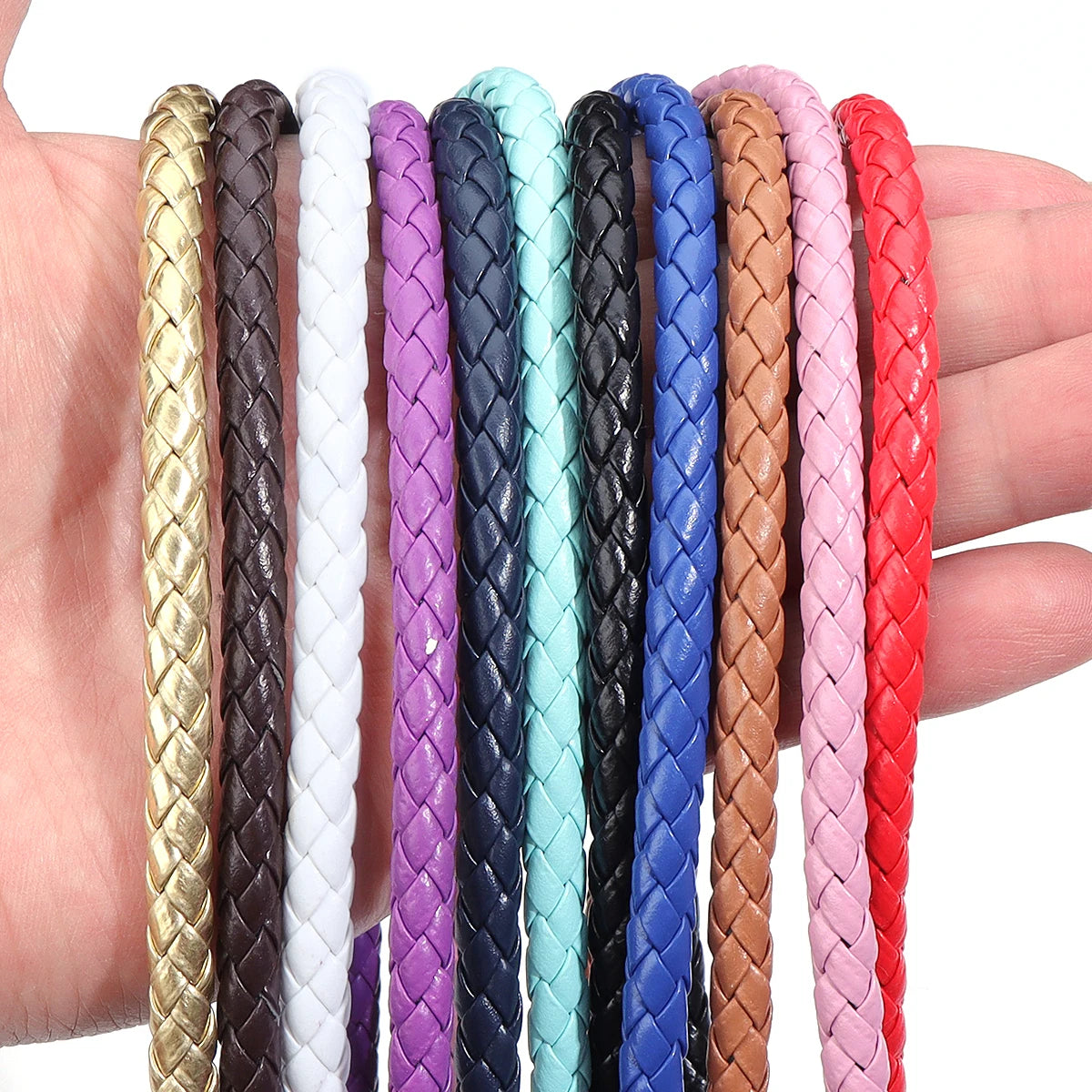A collection of round braided leather cords in various colors, including gold, black, white, purple, blue, and pink.