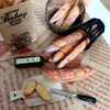 Handmade 1:6 scale miniature baguette for dollhouse kitchens displayed on brown paper.