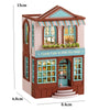 A wooden dollhouse kit of a pink princess villa with a striped awning and detailed facade.