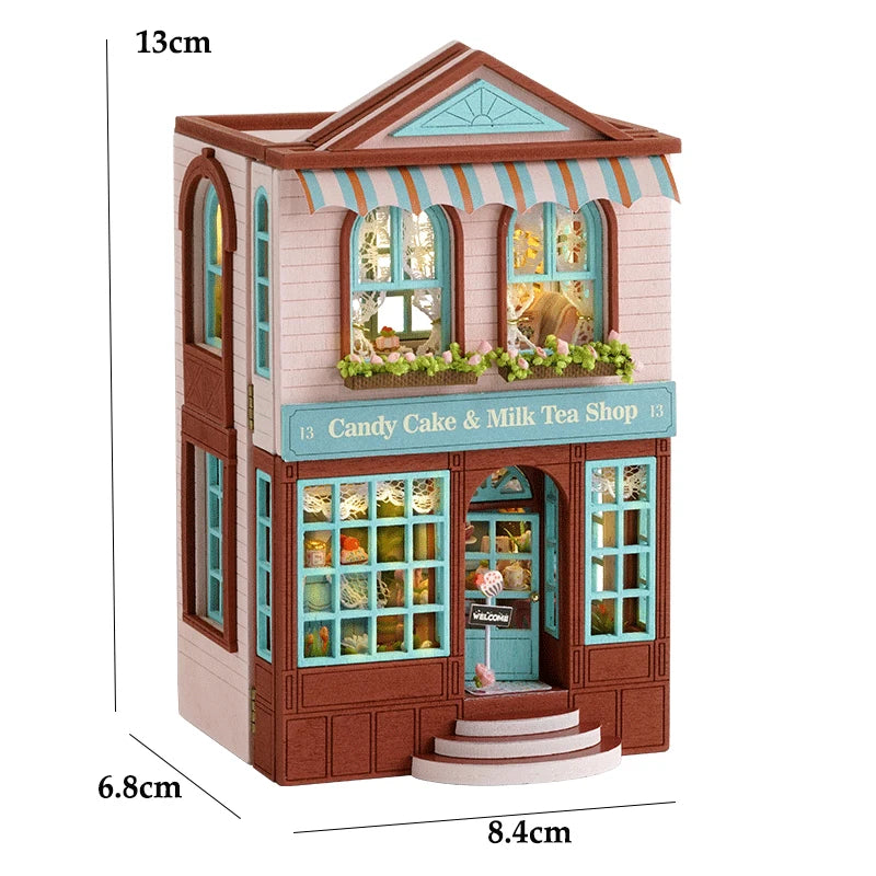 A wooden dollhouse kit of a pink princess villa with a striped awning and detailed facade.
