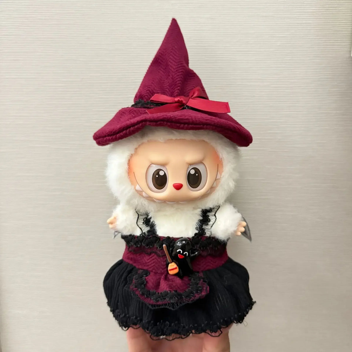 A handcrafted Halloween pumpkin costume set for a 17cm doll featuring a purple witch hat and black dress.
