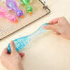 A hand squeezes a bright blue, sparkly stretchy duck toy for stress relief.