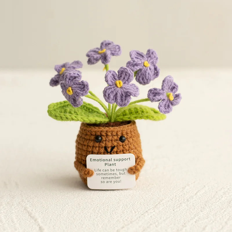 Handmade crochet plant with purple flowers growing from a brown pot