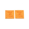 Two orange embossed leather labels with the text Made with Love stamped on them