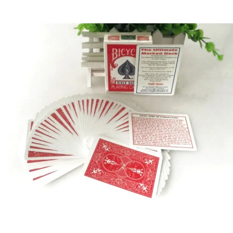 A stack of Bicycle Ultimate Marked Deck poker cards and a box are displayed on a white surface.