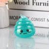 A bright teal glitter squishy stress ball shaped like a cute, smiling face resting on a reflective surface.